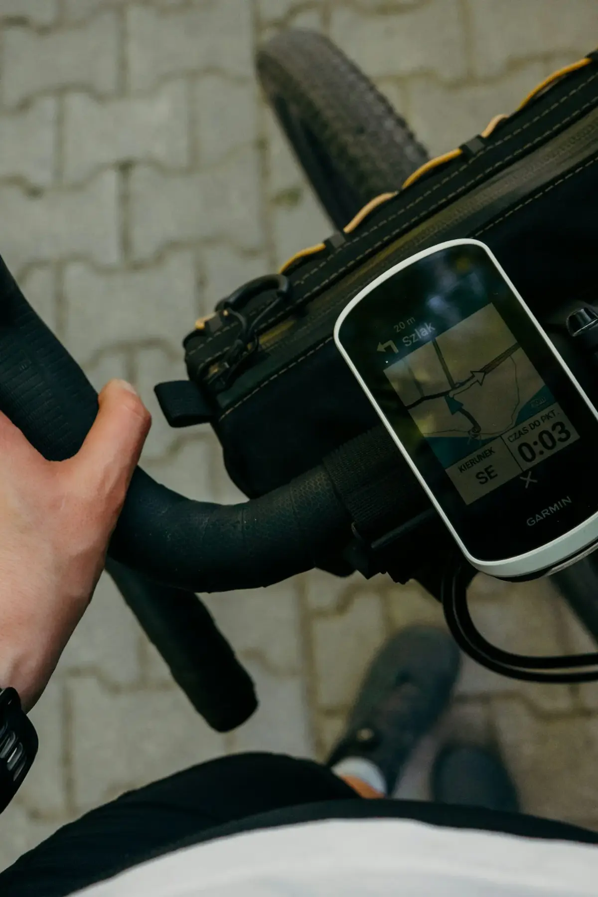 Main sur le cintre et compteur GPS affichant la carte